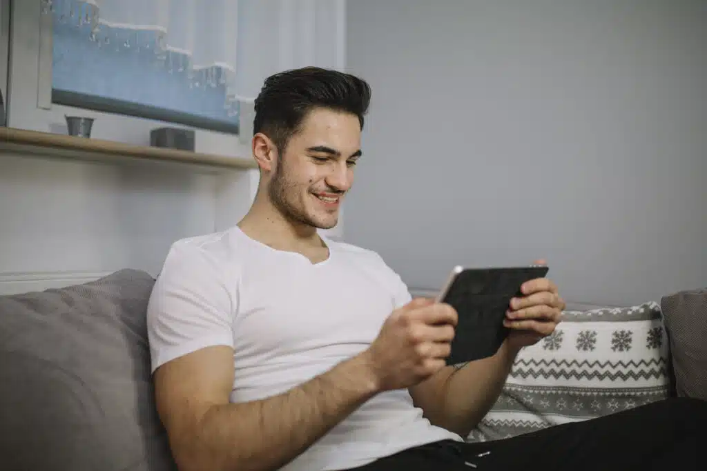 Mira películas y series gratis: ¡mira los grandes éxitos! 3 smiling man using tablet couch