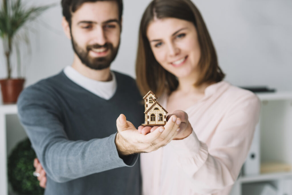 couple flou tenant une maison de jouets