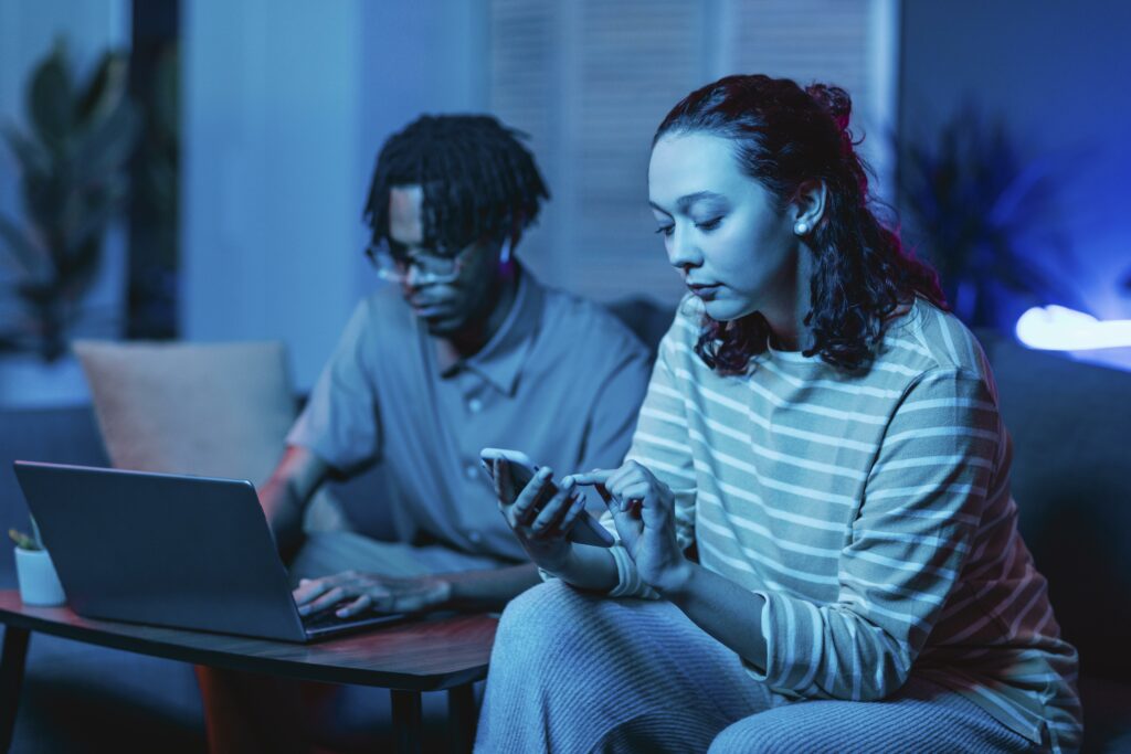 couple using their modern devices while home together