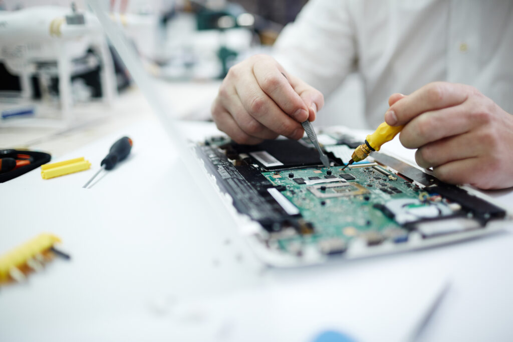 homme réparant un ordinateur portable de circuit imprimé