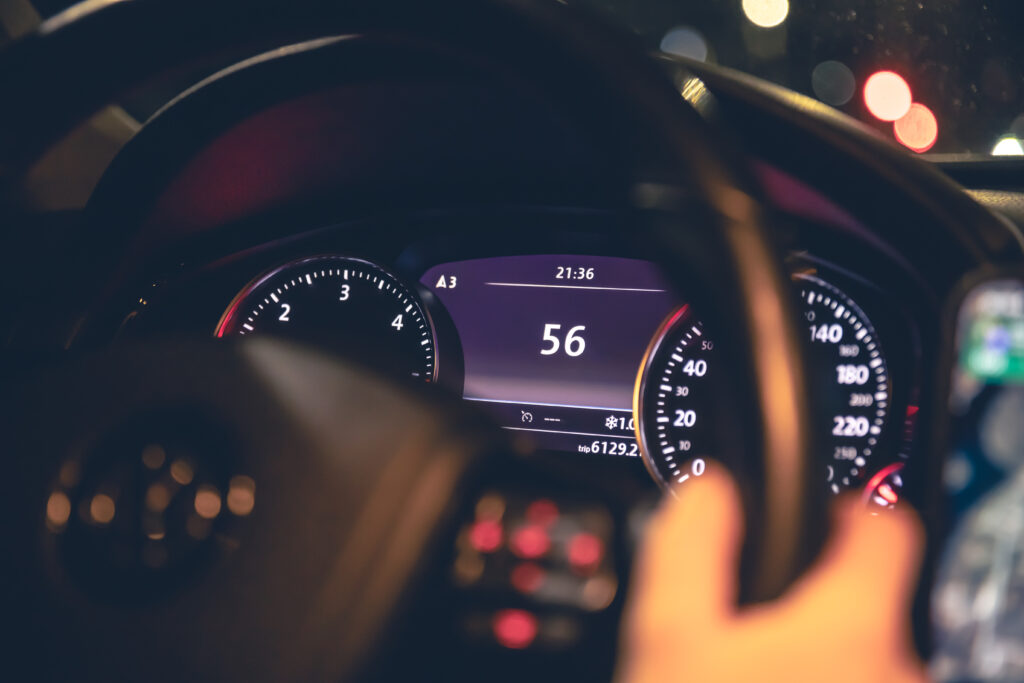 indicazione della velocità mani delle donne volante dell'auto di notte